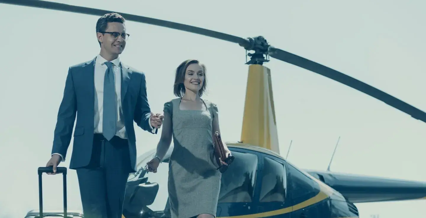 Man escorting woman from a helicopter ride